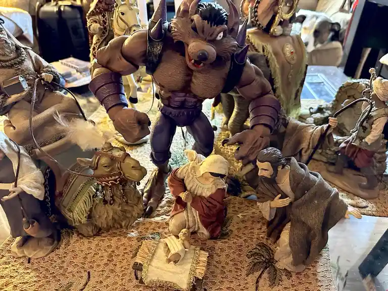 A nativity scene figurine set is humorously altered by replacing the traditional wise men with a large, muscular, horned…