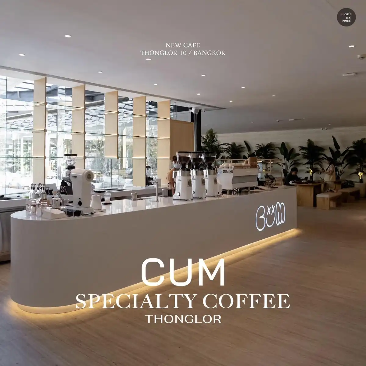 A modern, minimalist coffee shop interior with a curved white counter, multiple coffee grinders, and a neon sign spelling…