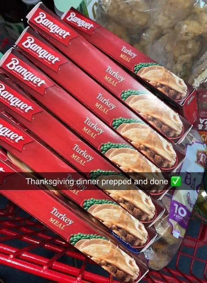 A shopping cart filled with multiple red boxes of Banquet Turkey Meal, a pre-made frozen dinner, with the overlaid text…