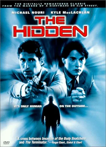 A movie poster for 'The Hidden' featuring two men pointing guns at a silhouetted figure in the foreground. The poster…