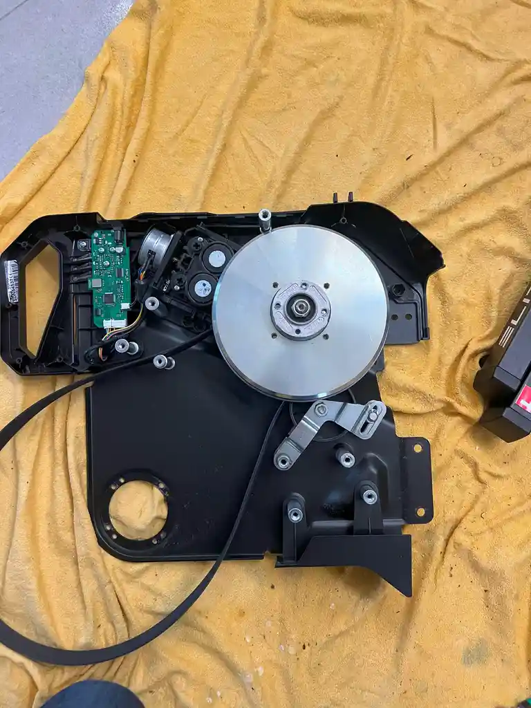 An overhead shot shows the internal components of a disassembled CD player, including a silver CD, green circuit board…