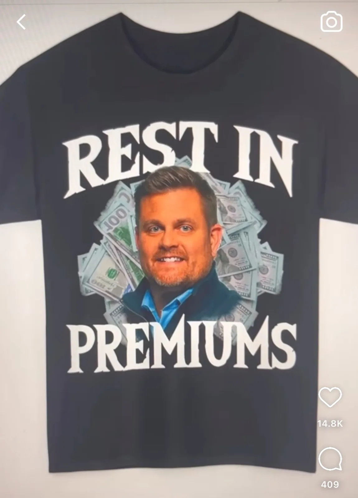 A black t-shirt displays a photo of a smiling man with a beard, surrounded by fanned-out US dollar bills. The text 'REST IN'…