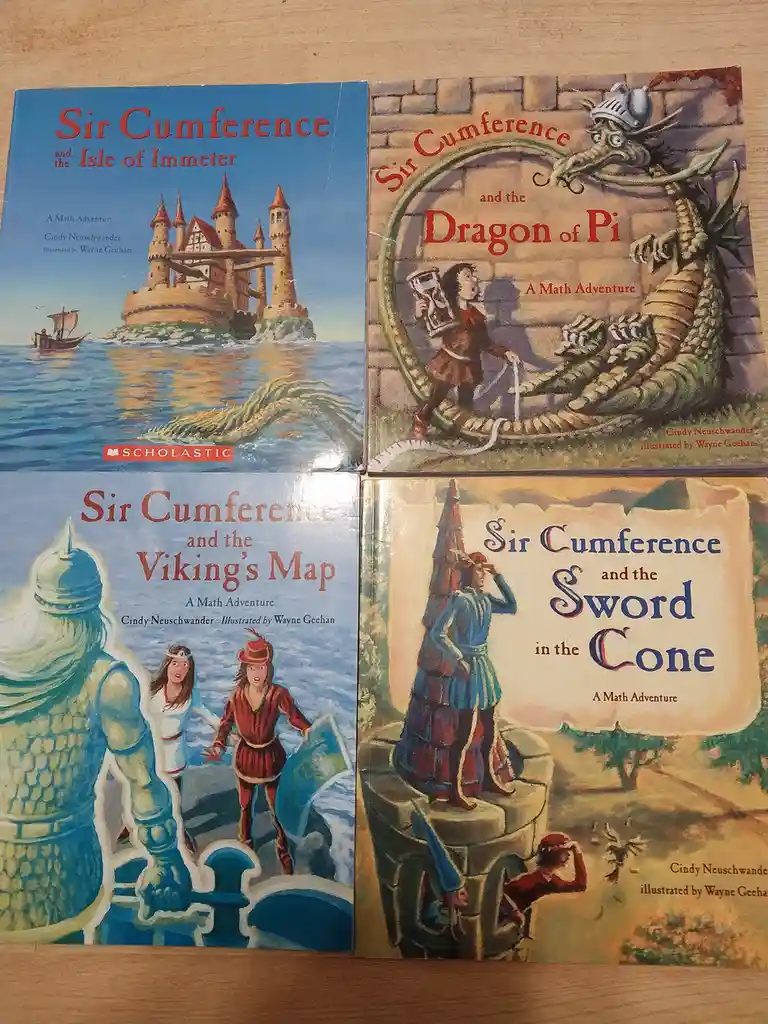 Four children's math adventure books by Cindy Neuschwander are displayed side-by-side on a wooden surface. Each cover…