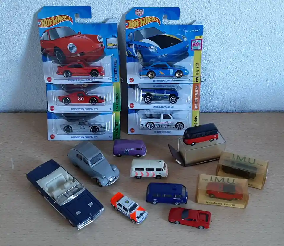 A collection of toy cars, including Hot Wheels models in their original blister packs and various other die-cast vehicles…
