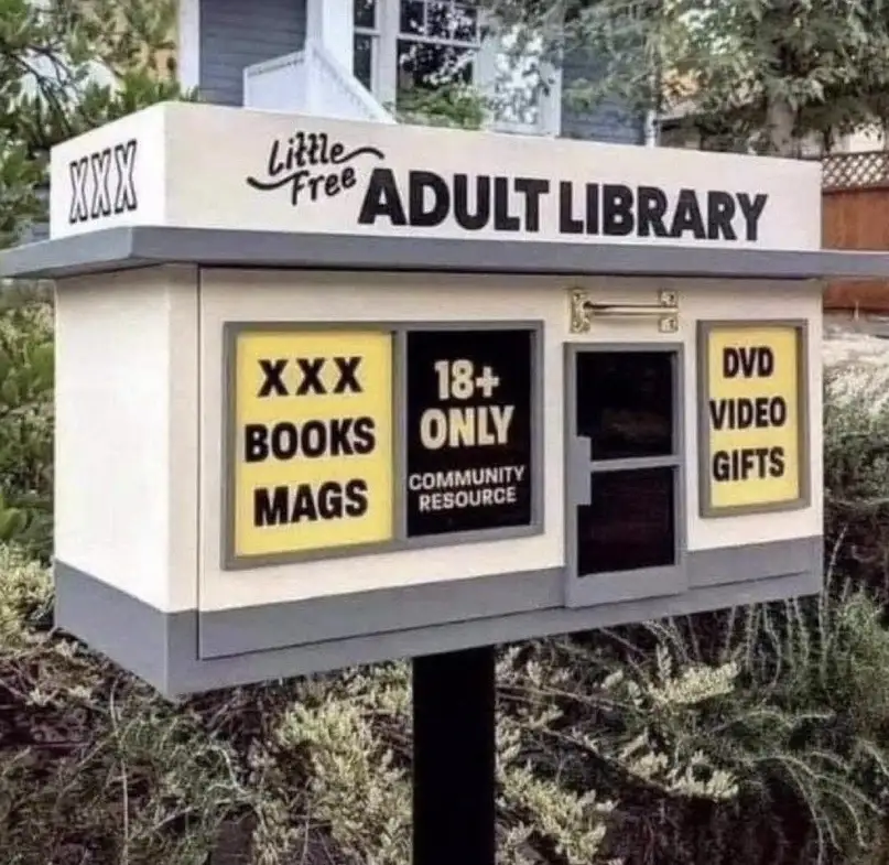 An outdoor Little Free Library box has been humorously modified with adult-themed signage. The top reads 'Little Free ADULT…