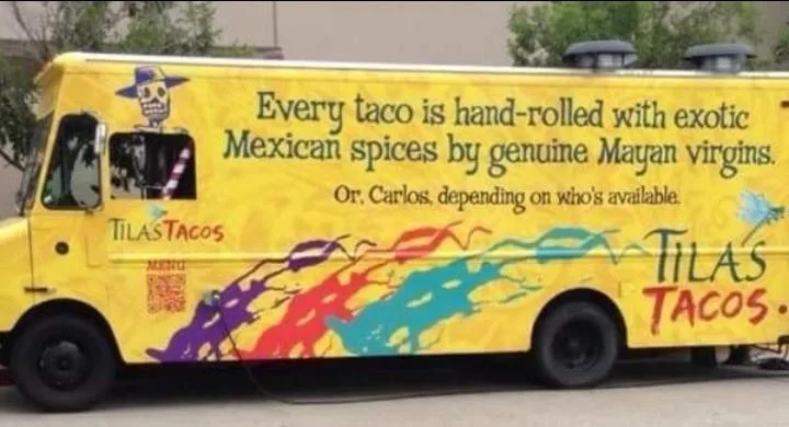 A yellow food truck named 'TILAS TACOS' has a large advertisement on its side. The text claims every taco is hand-rolled…
