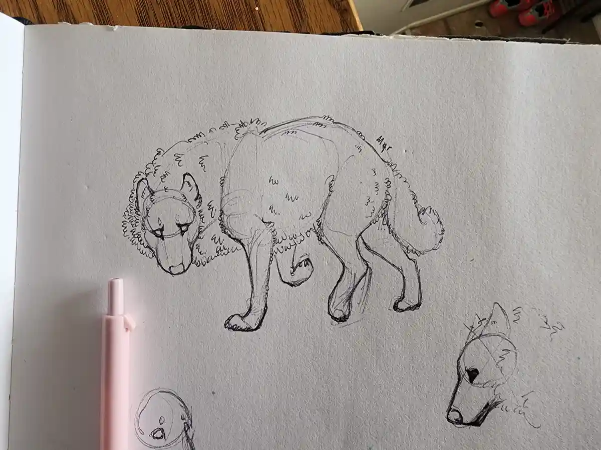 A sketchbook page shows a pencil drawing of a large, stylized wolf with exaggerated fluffy fur and a sad expression…