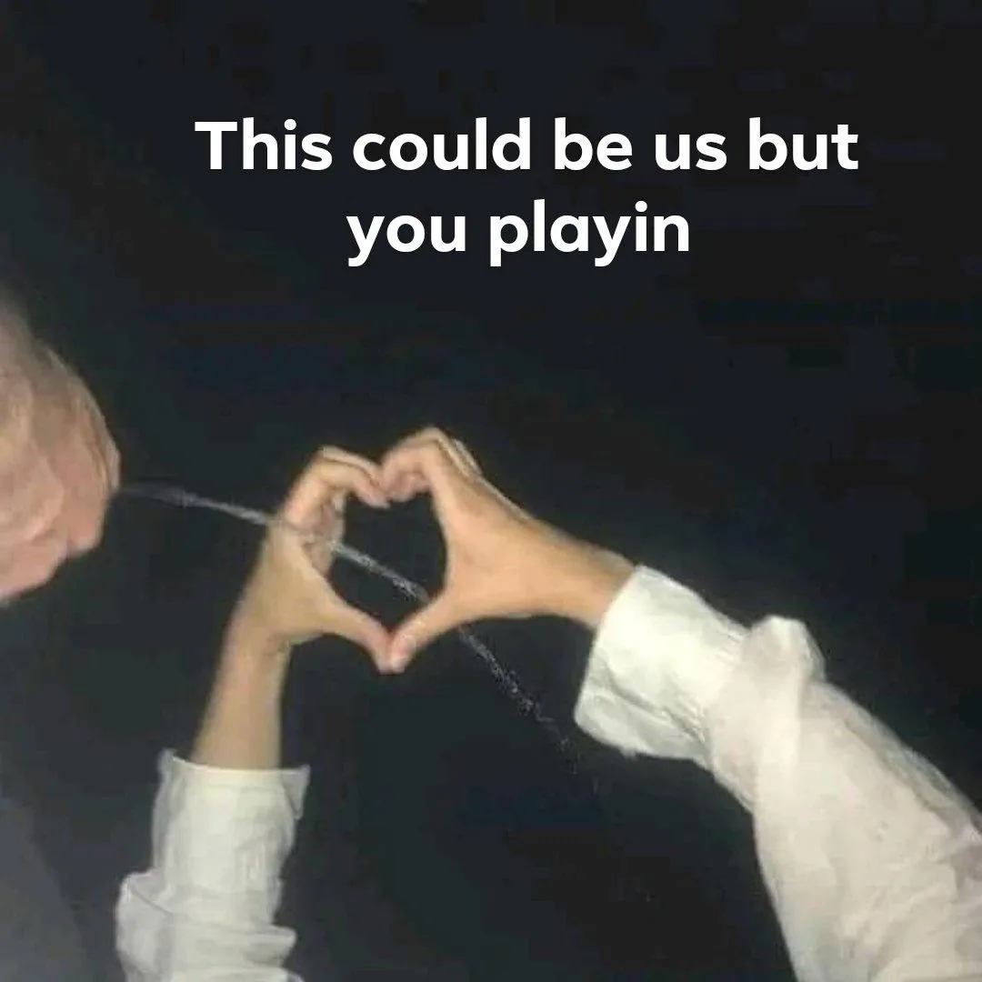 Two people are shown in a dark setting, both wearing white shirts, forming a heart shape with their hands. The image has…