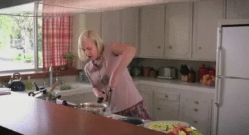 A woman in a kitchen is shown cooking, then looking at a large piece of meat in a pan, then washing dishes. She then looks…