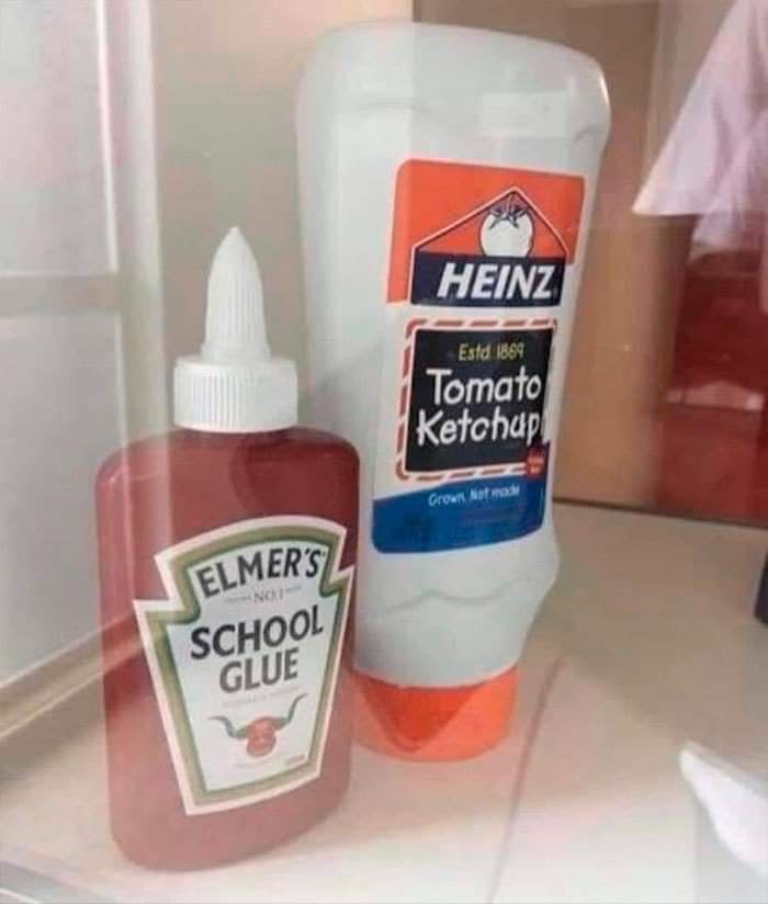 A photo shows a red bottle of Elmer's School Glue standing next to a larger white bottle of Heinz Tomato Ketchup, both…