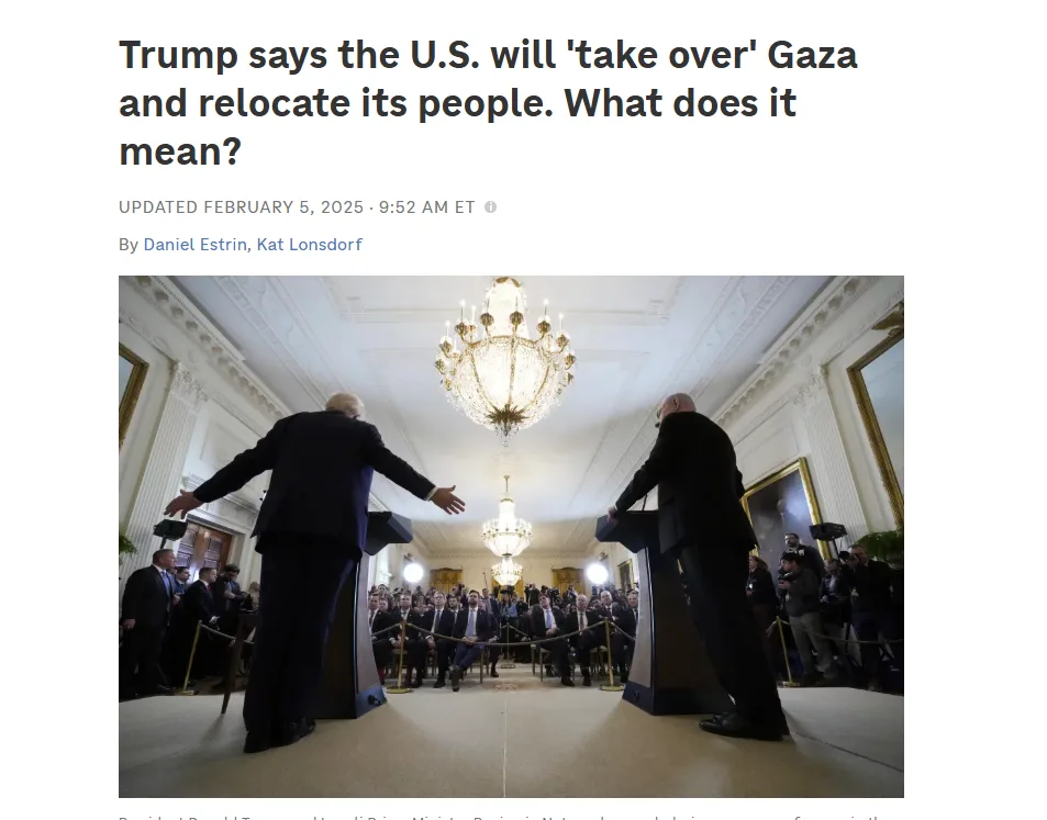 Two men stand at podiums facing each other in a grand, ornate room with chandeliers and a crowd of reporters. The man on the…