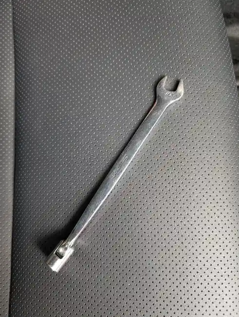 A shiny metal wrench with the number 10 stamped on its head and the brand name 'Snap-on' engraved on its shaft lies…