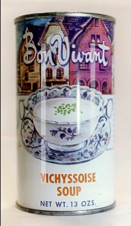 A vintage Bon Vivant brand can of Vichyssoise soup, featuring an illustration of a bowl of soup garnished with green herbs…