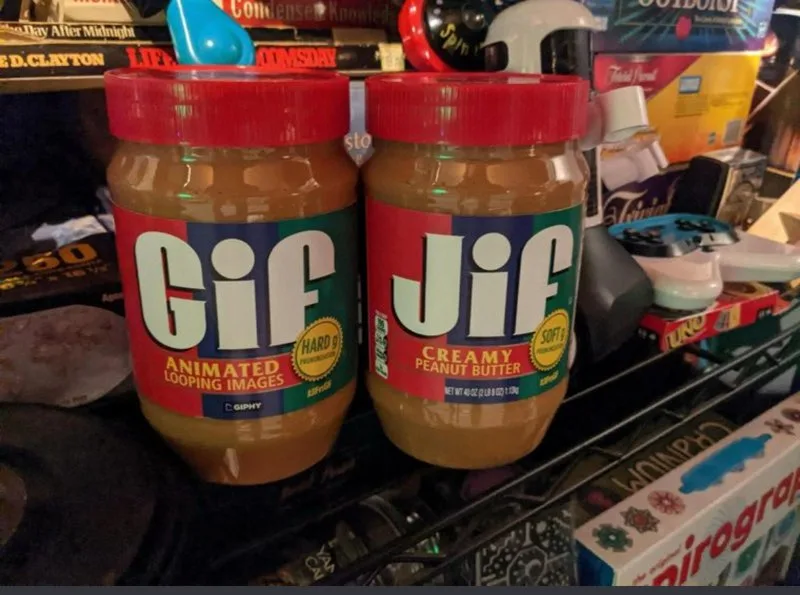 Two jars of peanut butter sit side by side on a cluttered shelf; the left jar has a label that reads 'Gif Animated Looping…