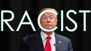 A man in a dark suit and red tie has his head superimposed over the letter 'C' in the word 'RACIST', which is displayed in…