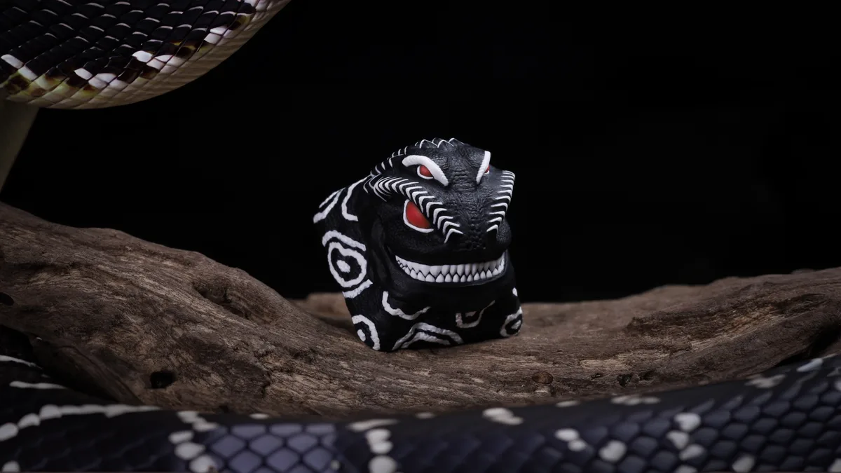 A black and white patterned snake is coiled around a dark wooden branch, with its head raised. In the center of the branch…