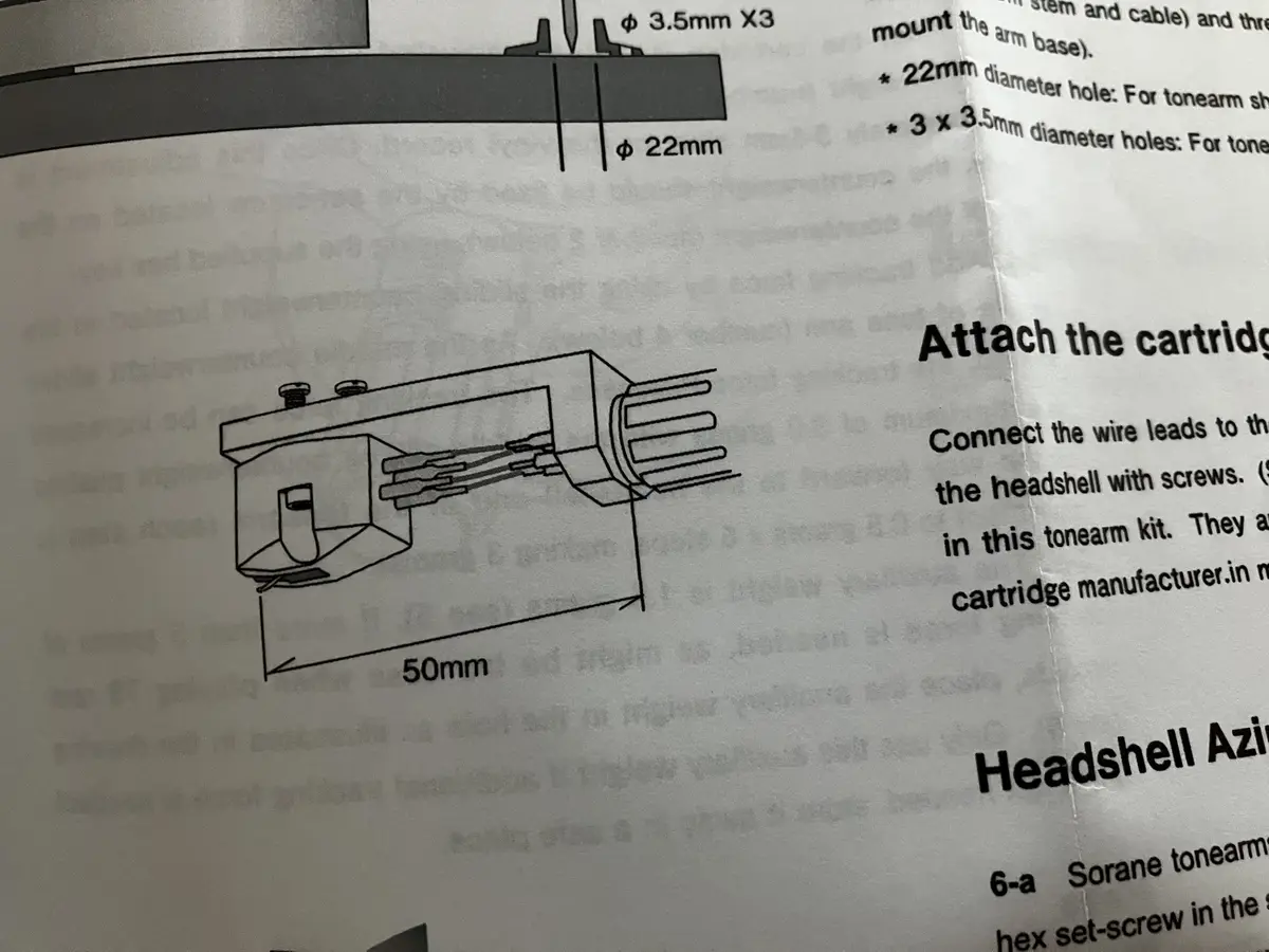 A close-up of a technical manual page showing a line drawing of a phonograph cartridge headshell with dimensions labeled…