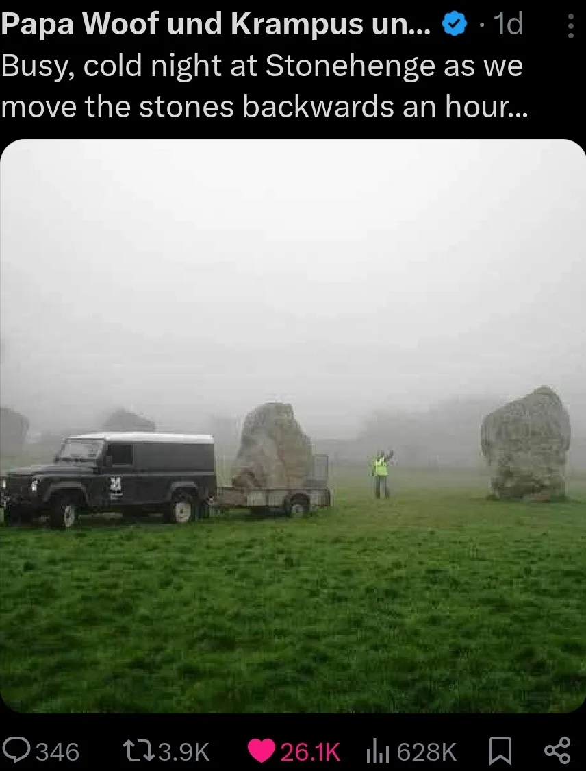 A foggy outdoor scene at Stonehenge shows a black Land Rover pulling a trailer with a large standing stone. Another large…
