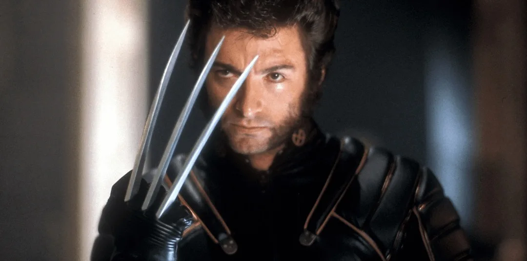 a close-up shot of the character Wolverine, played by Hugh Jackman, with his signature adamantium claws extended forward…