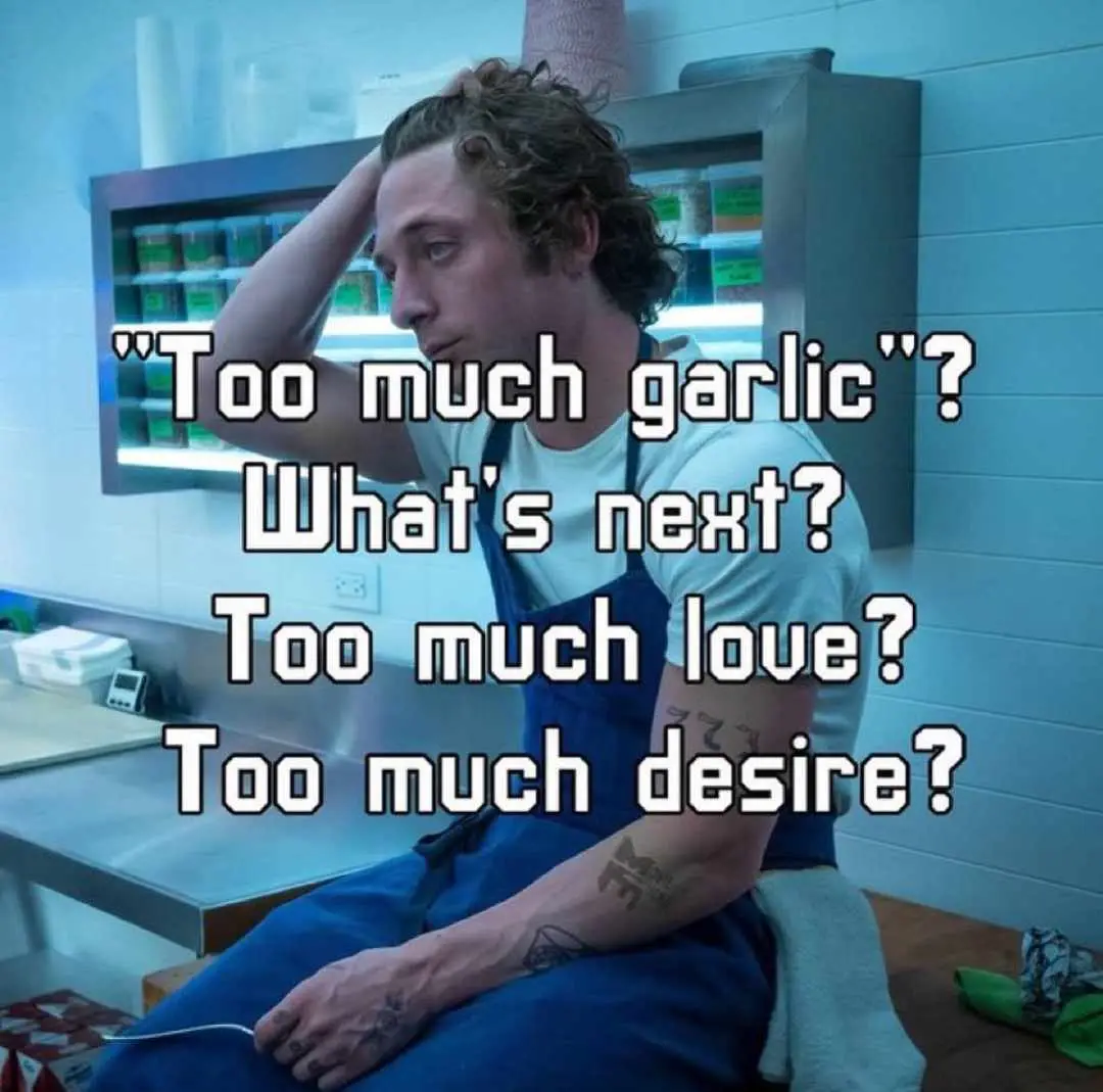 A man in a kitchen wearing blue overalls sits with his hand on his head, looking exasperated. Overlaid text reads: "Too much…