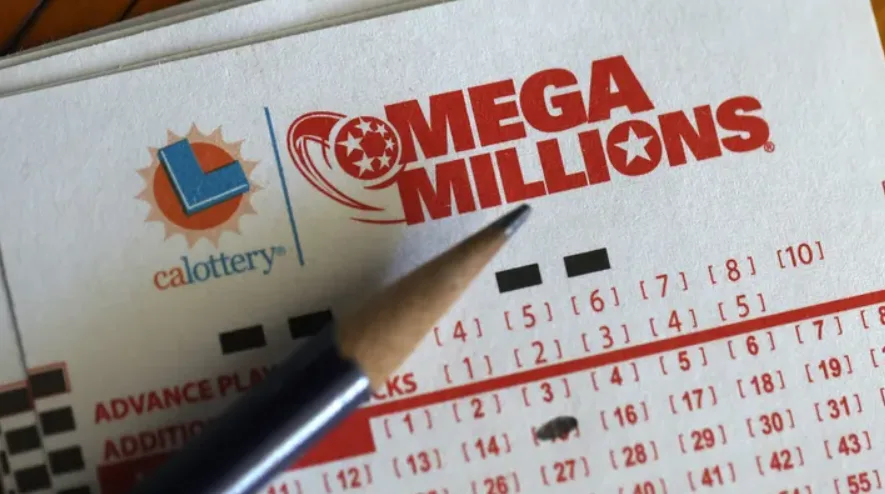 A close-up photo of a California Lottery Mega Millions ticket with a pencil resting on it, showing the red 'MEGA MILLIONS'…