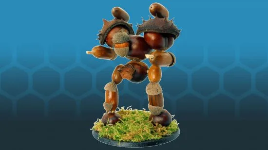 A figurine of a humanoid robot constructed entirely from acorns and oak leaves, standing on a mossy base against a blue…