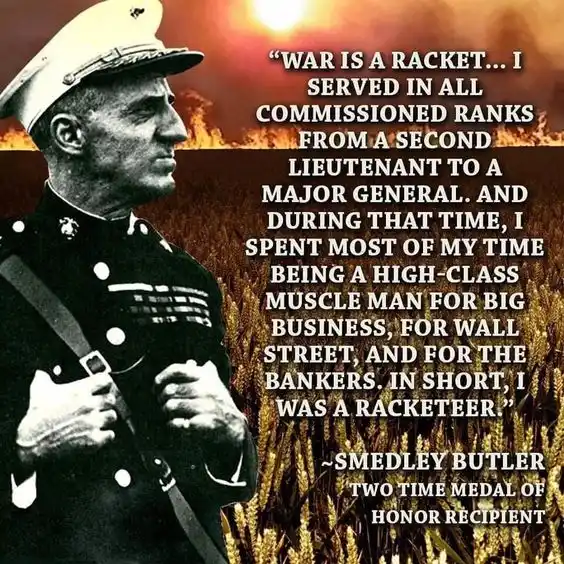 A black-and-white photo of a man in a military uniform, likely Smedley Butler, looking off to the side against a fiery…