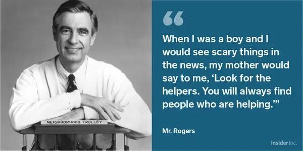 A black-and-white photo of Mr. Rogers smiling while leaning on a wooden podium labeled 'NEIGHBORHOOD TROLLEY'. To the right…