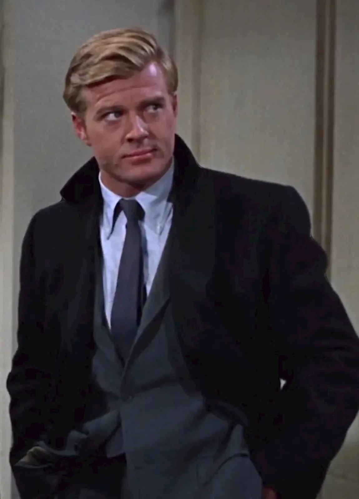 A man in a dark suit and tie looks sideways with a skeptical expression, overlaid with the text 'you're not supposed to be…