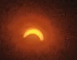 A blurry, low-resolution image shows a bright, glowing crescent shape against a dark, reddish-orange background, resembling…