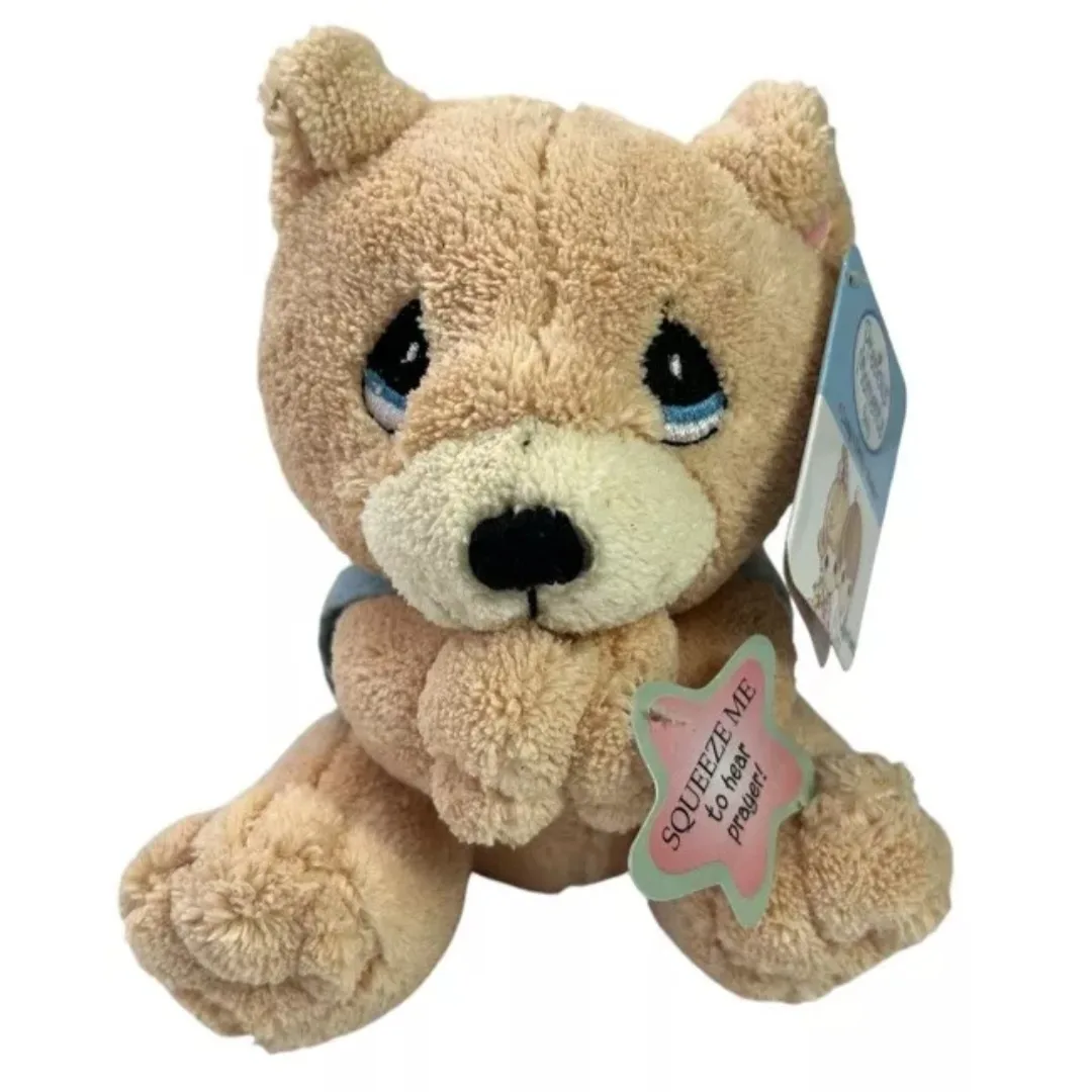 A light brown plush teddy bear with large, sad-looking eyes and a star-shaped tag attached to its paw that reads 'SQUEEZE ME…