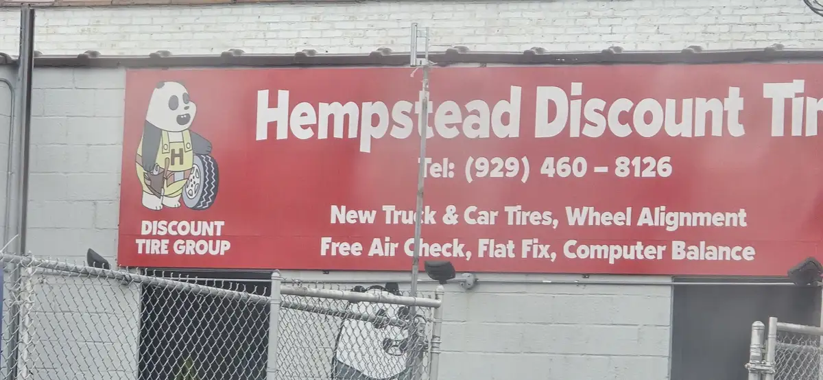 A red sign for 'Hempstead Discount Tire' features a cartoon panda in overalls holding a tire, with services listed below…