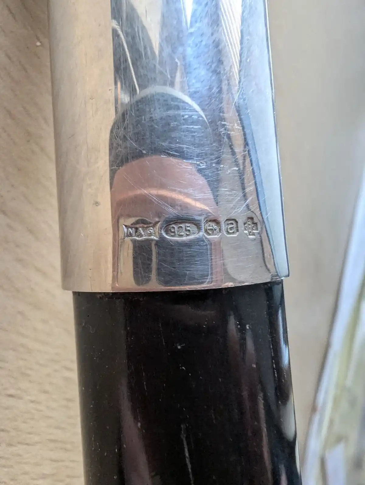 A close-up photo shows the silver hallmark on a pen's cap, which includes the maker's mark 'NAG', the sterling silver purity…