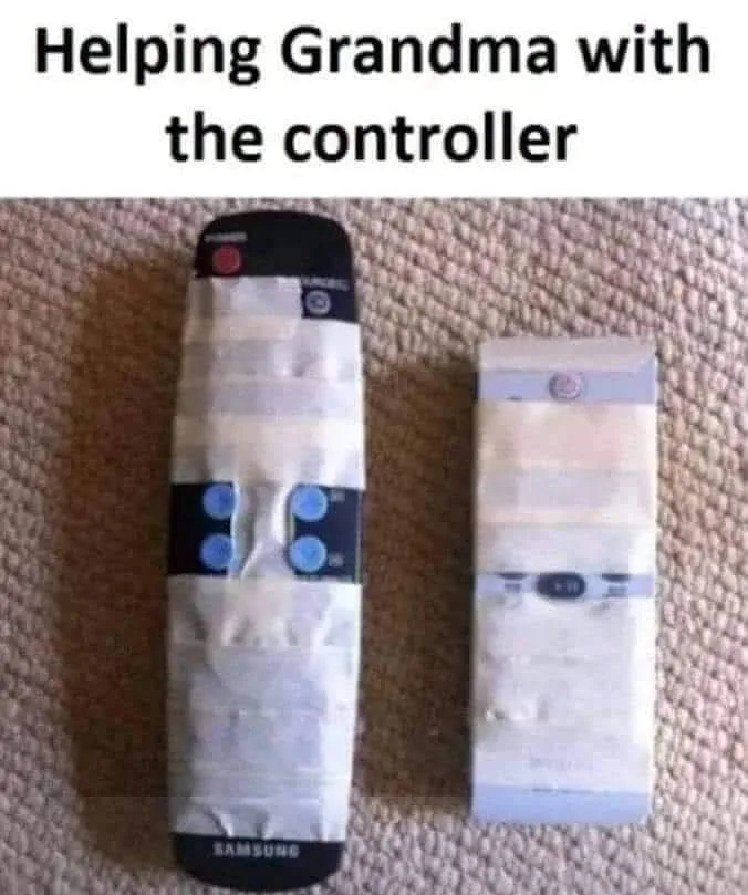 Two remote controls lie on a beige carpet, both wrapped in white tape. The larger one on the left is a Samsung remote with…