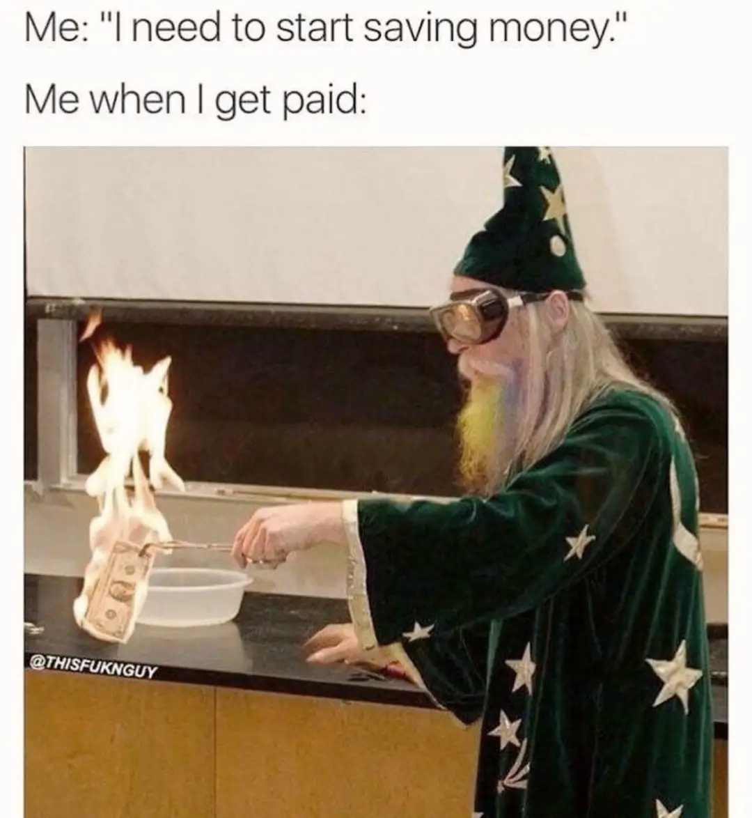 A man dressed as a wizard in a green robe and pointed hat, wearing goggles, uses tongs to hold a burning dollar bill over a…