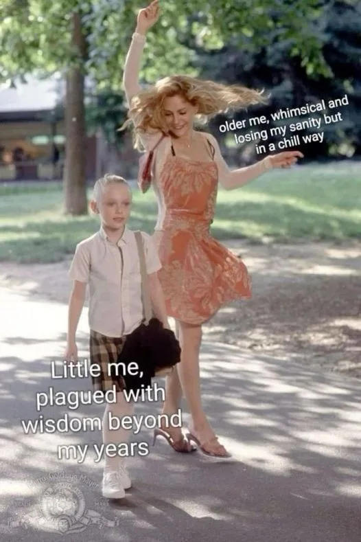 A still from the movie 'The Parent Trap' shows a young boy walking beside a woman in a flowing orange dress, both on a…