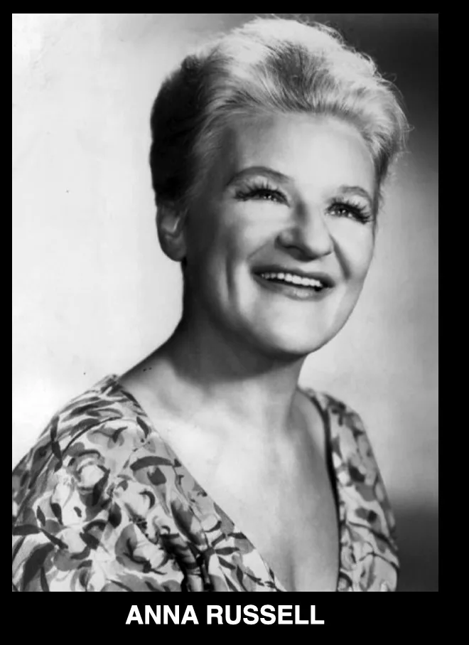 A black-and-white portrait of a smiling woman with short, styled white hair and a floral-patterned top. The name 'ANNA…