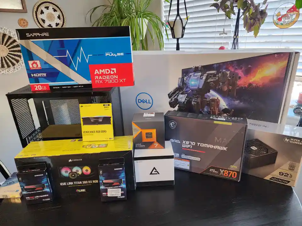 A collection of computer hardware boxes, including an AMD Radeon RX 7900 XT graphics card, AMD Ryzen 7 CPU, Corsair RAM, MSI…