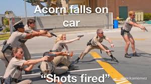 A group of people in military-style uniforms are aiming firearms in a parking lot. One person is crouched near a…